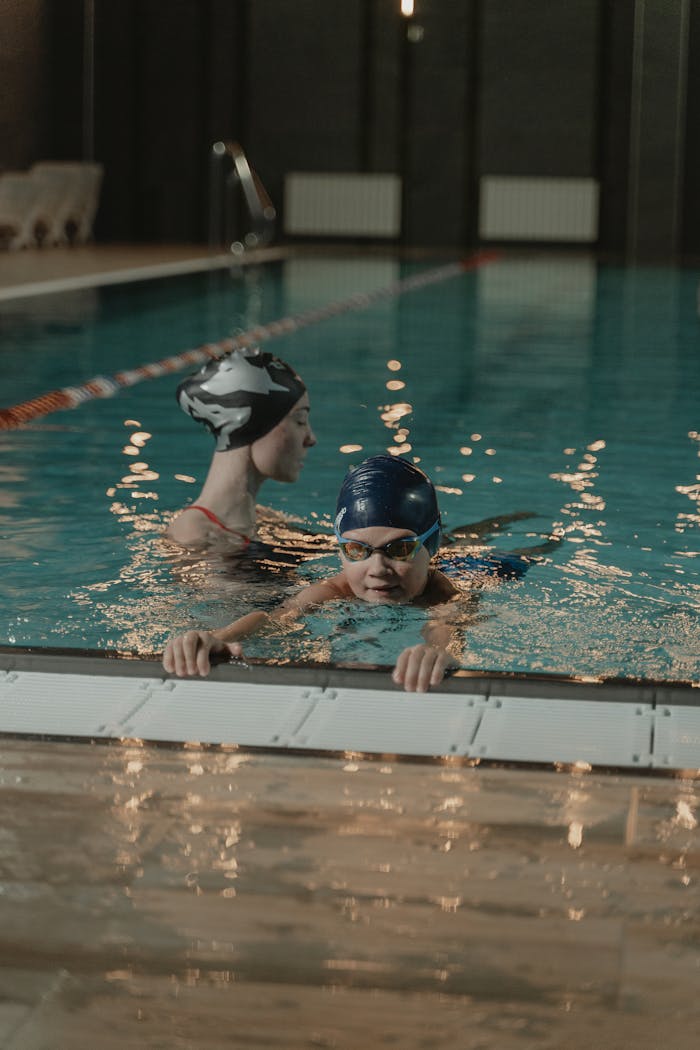 Crafting Captivating Headlines: Your awesome post title goes here Two adults practicing swimming in an indoor pool, emphasizing fitness and training.